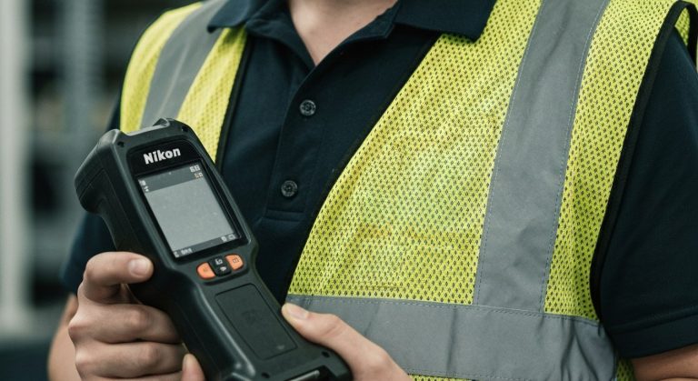 A close-up of a warehouse worker in a safety vest, focusing intensely while holding a handheld scanner.