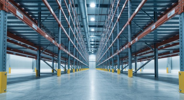 Wide shot of a modern, organized, climate-controlled warehouse interior with overhead industrial HVAC ducting.